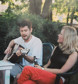 Picture of Ben singing and playing guitar with Becca